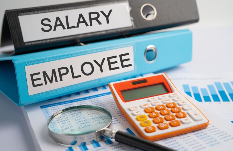Salary and Employee Binders and Documents on a Desk