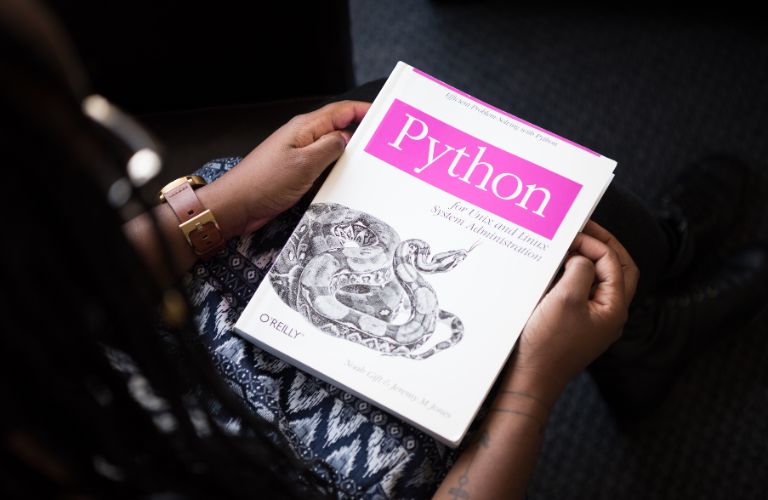 Woman Holding a Book About Python Programming